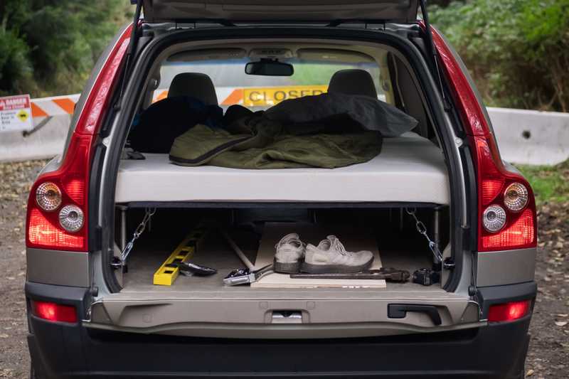 A SUV with its trunk open revealing a sleeping platform built into it